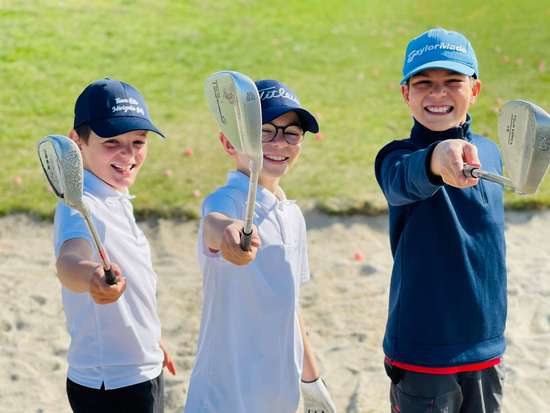 3 jeunes enfants golfeurs heureux et sportifs